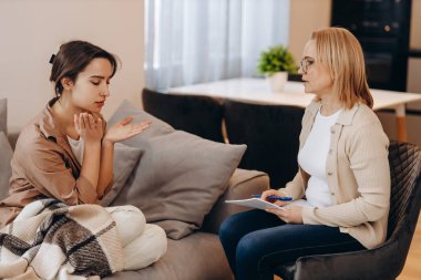 Sad frustrated woman talking in a session with a psychotherapist about her problems