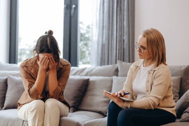 A young girl came for a consultation with a psychologist. She is very ashamed and covers her face with her hands.