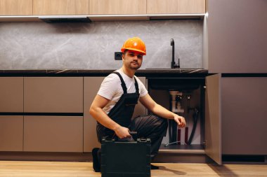 Mutlu genç erkek tesisatçı Mutfak Bataryası tespit.