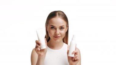 Elinde bir şişe şampuanla güzel bir sarışın kız. Parlak ve uzun saçlı kız. Uzun saçlı kadın. Kadın şampuan ve saç kremi tutuyor. Şampuan şişesi tutan kadın.