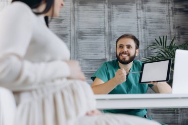 Hamile kadın klinikte doktoru ziyaret ediyor. Geçmişinde jinekolog olan çekici bir kadın..