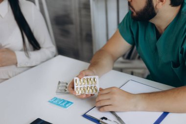 Hamilelik, jinekoloji, ilaç, sağlık ve insan konsepti - hastanede jinekolog doktor ve hamile kadın buluşması. Doktor hastasına hap gösteriyor..