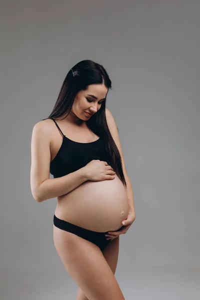 Mujer Embarazada Tocando Vientre Posando Sobre Fondo Gris —  Fotos de Stock