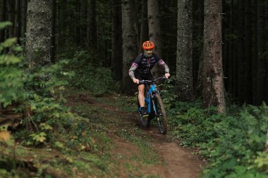 Bisikletçi bisiklete biner. Tepeden aşağı