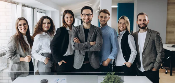 明るい近代的なオフィスに一緒に行に立っている多様な企業の同僚の笑顔のグループの肖像画 — ストック写真