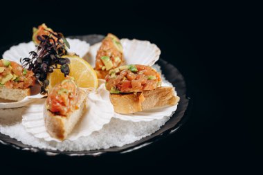 Soğuk balık aperatifi somon ve siyah tabakta avokado tartar.