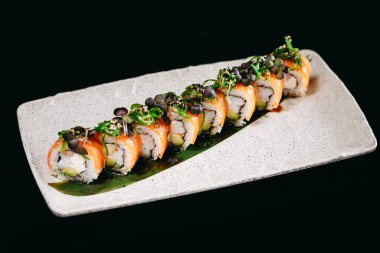 Somon, kaplan karidesi, krem peynir, avokado, Hiyashi-Wakame yosunu, fındık susamı sosu, unagi sosu, susam.