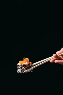 Tartaro rulosu Çin yemek çubuklarında elinde siyah arka planda