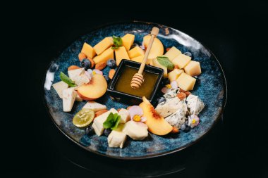 Bal, nektarin, yabanmersini ve fındıklı dilimlenmiş peynir.