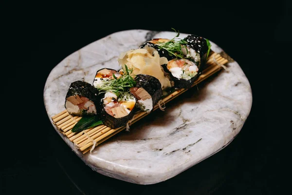 stock image Sushi Mansa Maki with salmon, eel, shrimp, cream cheese, tomago, cucumber, Unagi sauce, sesame on a stone tray