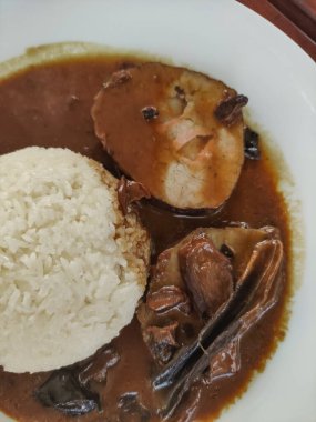 Haşlanmış domuz eti, mantar ve yanında beyaz pirinç ile servis edilen kahverengi sos..