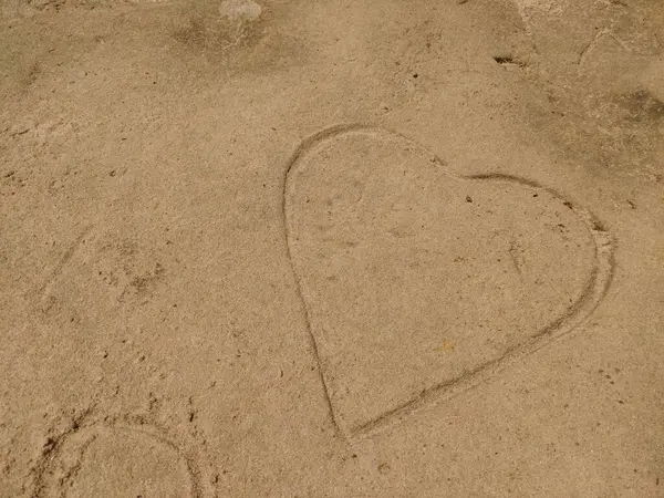 Kumsalda bir kalp çizilir.