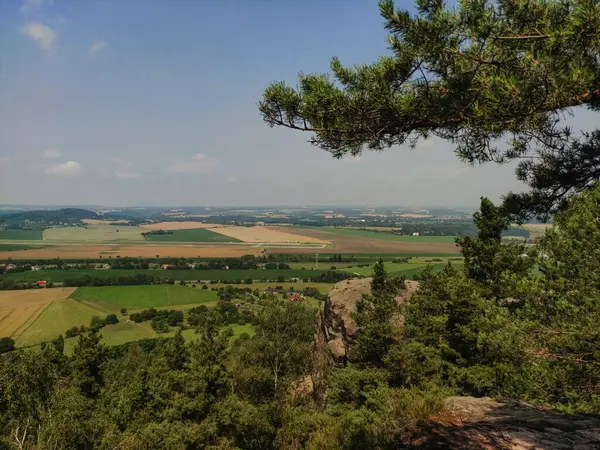 Çürüyen tepeleri ve uzak bir kasabası olan yemyeşil bir vadi manzarası..