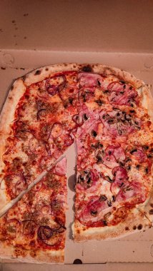 Jambon, mantar ve kırmızı soğanlı pizza dilimleri..