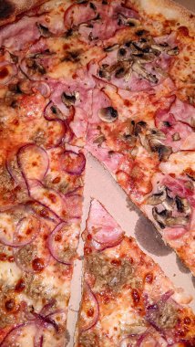 Jambon, mantar ve kırmızı soğanlı pizza dilimleri..