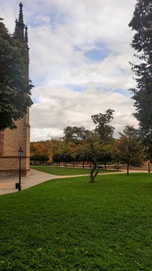 Ziyaretçiler, manzaralı bir sonbahar parkında huzurlu bir yürüyüş yapıyorlar..