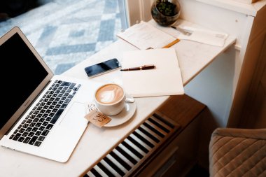 Prag, Çek Cumhuriyeti - 30 Kasım 2023: Kampa Kafe A çalışma alanı kahve ve dizüstü bilgisayarlı.