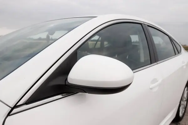 Prag, Çek Cumhuriyeti - 20 Temmuz 2021: Beyaz Mazda 6 gh. Temiz bir araba park yerine park edilmiş bulutlu bir gökyüzü yan aynaya yansıyor