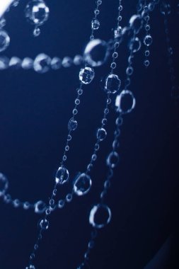 Kristal boncuklar Noel ya da yeni yıl kutlaması için karanlık bir arka planda asılı ve parlıyor.