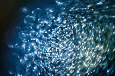 Soyut mavi şenlik arka planında ışıltılı ışıltı Bokeh etkisi yaratıyor