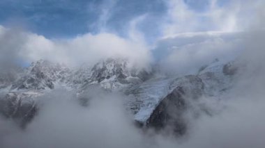 Bulutlar, kısmen sonbaharda karla kaplı bir şekilde, Mont Blanc Massif üzerinde hareket ediyor. Chamonix, Fransa Kasım Les Houches