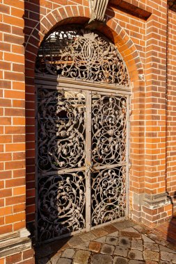 Berlin, Almanya - 15 Aralık 2019: Dekoratif, tuğla kemer yolu içine yerleştirilmiş, karmaşık tasarlanmış demir kapı, St. Marys kilisesinin mimari cazibesini artırıyor.