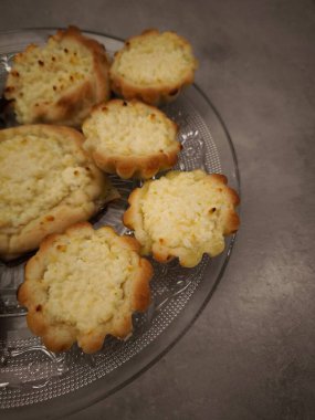 Yeni pişmiş mini cheesecake 'ler, dekoratif cam bir tabağın üzerinde oturuyorlar, çok cazip bir kopya alanı sunuyorlar.