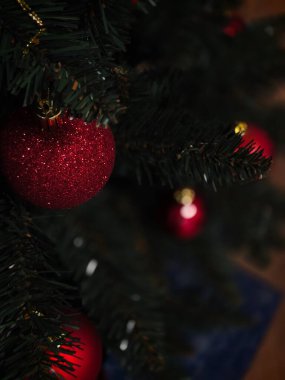 Yılbaşı ağacında asılı kırmızı, pırıl pırıl bir noel süsü. Yeni yıl için hazırlık kutuları.