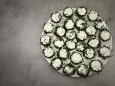 Krem peynirle kaplı salatalık dilimleri ve taze dereotlu lezzetli noel aperatifleri, aperatif olarak czechia parti yemekleri, yılbaşı yemeği, Noel ya da doğum günü yemeği.