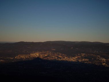 Czech cumhuriyetindeki dağların ardında güneş batarken Liberec kenti aydınlanıyor.