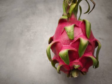 Canlı ejderha meyvesi nötr bir zemine karşı eşsiz dokusunu ve rengini sergiliyor