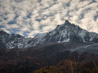 Kar manzaralı Mont Blanc, Fransa 'nın Chamonix şehrinde sonbahar mevsimi boyunca bulutlu bir gökyüzü altında dağları ve buzulları kapladı.