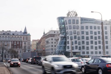 Prague, Czech republic - February 16, 2023: Cars driving on the road in front of the dancing house, a deconstructivist office building also known as fred and ginger clipart