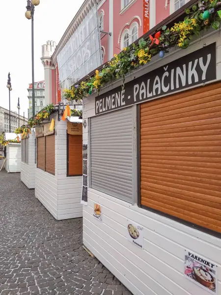 Prag, Çek Cumhuriyeti - 18 Mart 2018: Renkli çiçeklerle süslenmiş beyaz ahşap tezgahlar, bayram pazar kutlamaları sırasında tarihi kasaba meydanını süsleyen paskalya yumurtaları