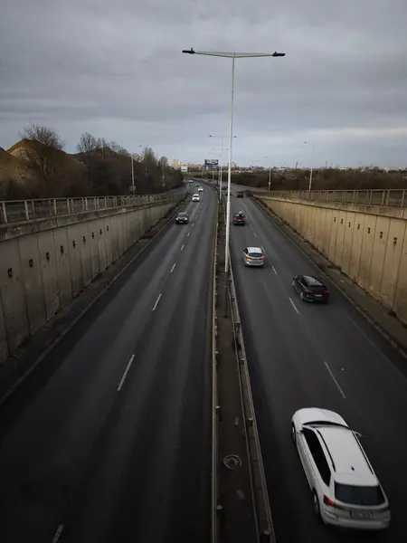 Prag, Çek Cumhuriyeti - 1 Ocak 2025: Çok sayıda araba bulutlu bir gökyüzünün altında, bir hareket ve kentsel yaşam hissi yaratarak otoyolda ilerliyor