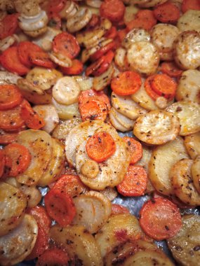 Havuçlu kavrulmuş kök sebzeler, maydanoz kökü ve patatesler, baharatlı ve taze otlarla süslenmiş, altın kahverengi karamelize kenarlı, kolay akşam yemeği