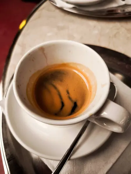 Klasik beyaz fincan ve çay tabağında servis edilen buharlı espresso kahvesi geleneksel Prag Kafe 'de bir masada dinleniyor ve Avrupa kahve kültürünün tadını çıkarıyor.