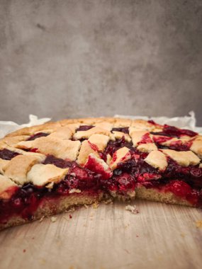 Ev yapımı vişneli turta dilimi, yumuşak kabuklu, romantik Prag ortamında narin porselen tabağın yanında dinleniyor.