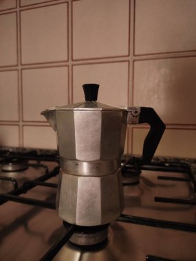 Geleneksel gaz sobasında zengin espresso demleyen antika moka demliği mutfak ortamında otantik İtalyan kahve kültürü sergiliyor.