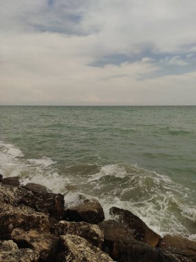 İtalya 'nın bibiyo şehrinde bulutlu bir gökyüzünün altında kayalık bir kıyıya vuran dalgalar temmuz ayında Adriyatik Denizi' nin güzelliğini yakalıyor.