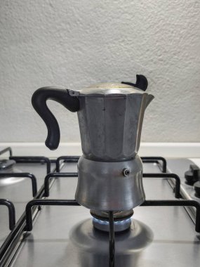 Gaz ocağında espresso demleyen eski moka demliği geleneksel İtalyan kahvesini sıcak mutfak atmosferiyle temsil ediyor.