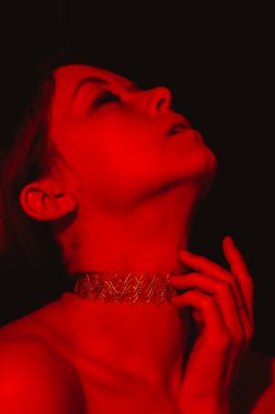 Dramatik kırmızı ışıklandırmalı portre zarif bir insan karmaşık bir boğucu giysisi giyiyor, esrarengiz bir ruh hali sergiliyor yoğun ışıklandırma ve zarif tasarım kitabı kapağı Sevgililer Günü kapağı kapağı