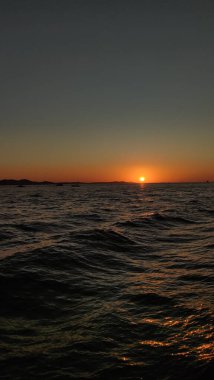 Hırvatistan 'da sakin denizin üzerinde altın gün batımı yaz tatilinde büyülü bir atmosfer yaratıyor.