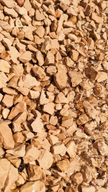 Hırvatistan 'da güneşli bir yaz gününde pürüzsüz çakıl taşlarının üzerinden akan temiz su güzel ışık ve gölge desenleri yaratıyor.