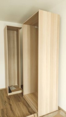 Kısmen monte edilmiş ahşap gardırop çağdaş dairede duruyor Prag 'da, Czech Cumhuriyeti' nde mobilya montaj sürecini sergiliyor.