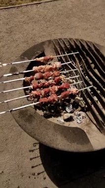 Güneşli bir yaz gününde Prag 'da ızgara yapan leziz et şişlerinin dikey yüksek kaliteli görüntüsü havayı ağız sulandıran aromalar ve canlı tatlarla dolduruyor.