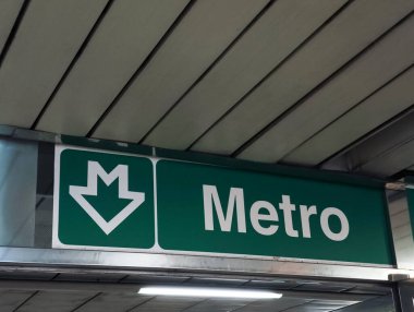 Prag, Çek Cumhuriyeti - 25 Mart 2025: Prag 'ın yeraltı ulaşım sistemindeki yolculara rehberlik eden beyaz m ve aşağı doğru ok ile yeşil metro işareti