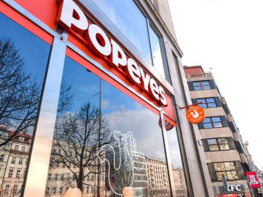 Prag, Çek Cumhuriyeti - 25 Mart 2025: Popeyes fast food restoranının dışında, Prag 'daki Wenceslas Meydanı' nda arka planda fast food üzerine kurulu tabela ve amblem sergileniyor.
