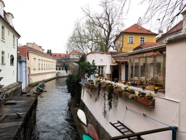 Prag, Çek Cumhuriyeti - 26 Mart 2025: Prag, Czechia 'da renkli binalar, çiçek kutuları ve kanolarla kaplı certovka kanalını yakalayan yayın resmi