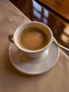 Creamy Coffee Lungo, Prag Kafe 'deki bir masada beyaz bir fincanda dinleniyor. Baharın atmosferini yansıtıyor.